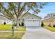 House exterior showcasing a white garage door and landscaping at 2627 Oneida Loop, Kissimmee, FL 34747