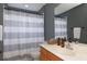 Clean bathroom with wood vanity and gray shower curtain at 2793 Lido Key Dr, Kissimmee, FL 34747