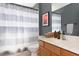 Bathroom with wood vanity and gray striped shower curtain at 2793 Lido Key Dr, Kissimmee, FL 34747