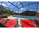 Relaxing pool and spa with lounge chairs under a screened enclosure at 2793 Lido Key Dr, Kissimmee, FL 34747