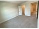 Bright bedroom with neutral decor, plush carpeting, and a large closet at 3031 Tackle Drive, Leesburg, FL 34748