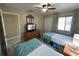 Two twin beds, TV, dresser, and ceiling fan in a well-lit bedroom at 3187 Sea World Ct, Kissimmee, FL 34746