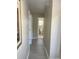 Long hallway with light walls and wood-look floors, offering access to multiple rooms at 3187 Sea World Ct, Kissimmee, FL 34746