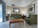 Living room with green sofa and armchairs, coffee table at 3187 Sea World Ct, Kissimmee, FL 34746