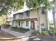 Charming townhome with a red tile roof, arched entryway, and well-manicured landscaping at 3197 Sea World Ct, Kissimmee, FL 34746