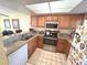 Efficient kitchen features stainless steel appliances, tile backsplash, and breakfast bar seating at 3197 Sea World Ct, Kissimmee, FL 34746