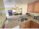 Open kitchen view with granite counters, stainless steel appliances, and access to the rest of the house at 3197 Sea World Ct, Kissimmee, FL 34746