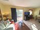 Cozy living room features a sliding door to a patio, comfortable seating, and a television for entertainment at 3197 Sea World Ct, Kissimmee, FL 34746