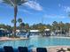 Community pool with lounge chairs and a beautiful view of palm trees under a sunny sky at 3197 Sea World Ct, Kissimmee, FL 34746