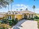 Beautiful yellow house with a brick driveway and lush landscaping at 4 Arika At Lionspaw, Daytona Beach, FL 32124