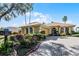Landscaped front yard with a yellow house and brick driveway at 4 Arika At Lionspaw, Daytona Beach, FL 32124