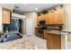 Kitchen features granite counters, stainless steel appliances, and wood cabinets at 4 Arika At Lionspaw, Daytona Beach, FL 32124