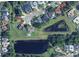 Aerial view of property with a pool overlooking two ponds, surrounded by lush landscaping at 4001 Misty Morning Pl, Casselberry, FL 32707