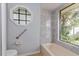 Clean bathroom featuring a tiled shower and tub with a large window providing natural light at 4001 Misty Morning Pl, Casselberry, FL 32707