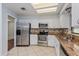 Bright kitchen features stainless steel appliances, granite countertops, and white cabinetry at 4001 Misty Morning Pl, Casselberry, FL 32707