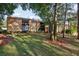 Tan two-story condo building with balconies, surrounded by lush landscaping at 600 Cranes Way # 206, Altamonte Springs, FL 32701