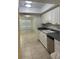 Galley-style kitchen has sleek white cabinets and tile floors, connecting to the living area at 607 Waverly Ln # 403, Maitland, FL 32751