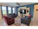 Relaxing living room featuring ample seating and a blue accent wall at 648 Daring Dr, Davenport, FL 33837