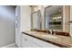 Bathroom featuring double sinks with granite countertops, framed mirrors, and custom cabinets at 660 Killarney Bay Ct # 6, Winter Park, FL 32789