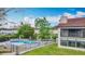 View of the community pool and building exterior showing the screened lanai and tile roof at 660 Killarney Bay Ct # 6, Winter Park, FL 32789