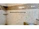 Close-up of stone-like tiled shower featuring a soap and shampoo niche and chrome grab bar at 660 Killarney Bay Ct # 6, Winter Park, FL 32789