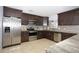 Modern kitchen featuring dark wood cabinets, granite countertops, and stainless steel appliances at 711 Cypress Ave, Orange City, FL 32763