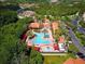 Aerial view of community pool and clubhouse, nestled in a lush, green landscape at 8020 Tuscany Way # 6401, Davenport, FL 33896