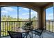 Screened balcony with table and chairs, offering a view of nature and highway at 8020 Tuscany Way # 6401, Davenport, FL 33896