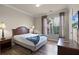 Comfortable bedroom with a bed, side tables, and a window offering natural light at 8020 Tuscany Way # 6401, Davenport, FL 33896