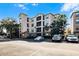 Exterior of building showing parking and beautiful landscaping in a Mediterranean-style community at 8020 Tuscany Way # 6401, Davenport, FL 33896