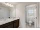 Bathroom with double vanity, dark cabinets, and a separate toilet area at 828 Scrub Oak Hammock Rd, Davenport, FL 33837