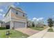 Two-story house with gray siding, stone accents, and a two-car garage at 828 Scrub Oak Hammock Rd, Davenport, FL 33837