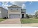 Two-story house with gray siding, stone accents, and a two-car garage at 828 Scrub Oak Hammock Rd, Davenport, FL 33837