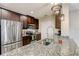 Kitchen with granite counters, dark wood cabinets, and stainless steel appliances at 828 Scrub Oak Hammock Rd, Davenport, FL 33837