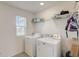 Laundry room with washer, dryer, shelving, and a window at 828 Scrub Oak Hammock Rd, Davenport, FL 33837