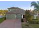 Two-story house, three-car garage, brick driveway, and landscaped yard at 941 Orchard Charm Ct, Oviedo, FL 32765