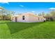 Single-story home's side view with covered patio and lush green lawn at Tbd Marion Oaks Ln, Ocala, FL 34473