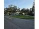 View of light blue home with mature trees and manicured lawn from the street corner at 1026 Lake Jessamine Dr, Orlando, FL 32839