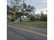 Light blue home with mature trees, manicured lawn, and asphalt driveway leading to the street at 1026 Lake Jessamine Dr, Orlando, FL 32839