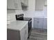 Bright kitchen featuring gray cabinets, stainless steel appliances, and quartz countertops at 1026 Lake Jessamine Dr, Orlando, FL 32839