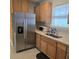 Kitchen featuring wood cabinets, stainless steel refrigerator, and speckled floor at 1026 Lake Jessamine Dr, Orlando, FL 32839