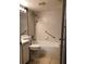 Bathroom with white tiled walls, grab bars and a bathtub with shower fixture at 1313 S Pine Ridge Cir # C1, Sanford, FL 32773