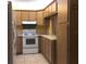Kitchen featuring white appliances and oak cabinets with ceramic tile flooring, countertop, and backsplash at 1313 S Pine Ridge Cir # C1, Sanford, FL 32773