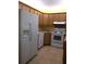 Kitchen featuring white appliances and oak cabinets with tile backsplash and ceramic flooring at 1313 S Pine Ridge Cir # C1, Sanford, FL 32773