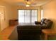 Living room featuring a leather sofa set, entertainment center, and sliding doors that bring in natural light at 1313 S Pine Ridge Cir # C1, Sanford, FL 32773