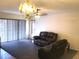 Carpeted living room featuring a leather sofa set, chandelier, ceiling fan, and sliding glass doors at 1313 S Pine Ridge Cir # C1, Sanford, FL 32773