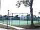 Well-maintained community tennis court surrounded by mature trees and lovely residential buildings at 1313 S Pine Ridge Cir # C1, Sanford, FL 32773