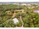 Aerial view of a beautiful community featuring walking paths and a calm lake surrounded by verdant trees at 16737 Meadows St, Clermont, FL 34714