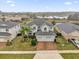 Aerial view of house featuring a well-manicured lawn, a brick driveway, and a three-car garage at 16737 Meadows St, Clermont, FL 34714