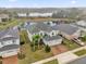 Aerial view of house featuring a well-manicured lawn, a brick driveway, and a three-car garage at 16737 Meadows St, Clermont, FL 34714